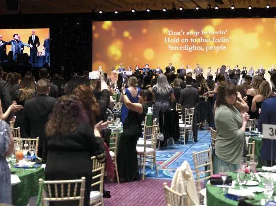 Training MVP winners join Hall of Famers and sponsors (on stage) in a rousing rendition of Journey’s “Don’t Stop Believin’.” PHOTOGRAPHY BY HUGHES FIORETTI PHOTOGRAPHY
